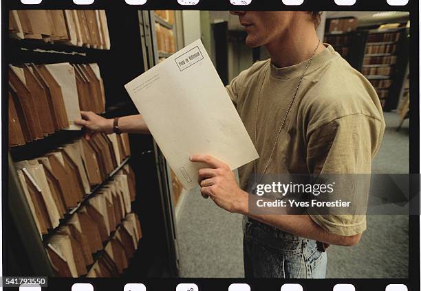 Man puts a file in the non computerized files library at Interpol's new headquarters.