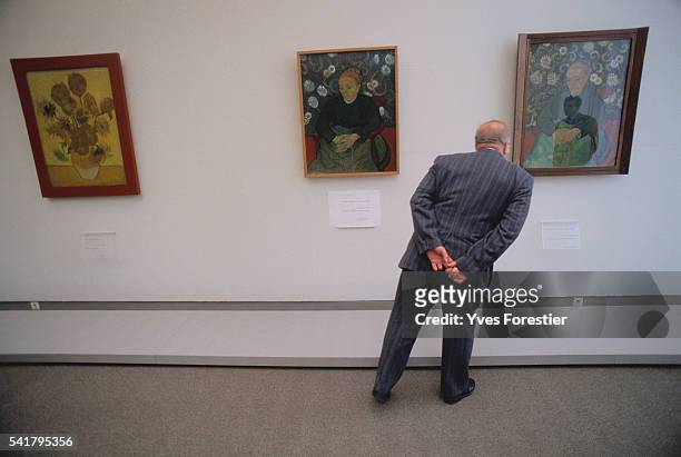 Man looks at Van Gogh paintings at the Van Gogh museum of Amsterdam for the opening of the Great Van Gogh Exhibition.