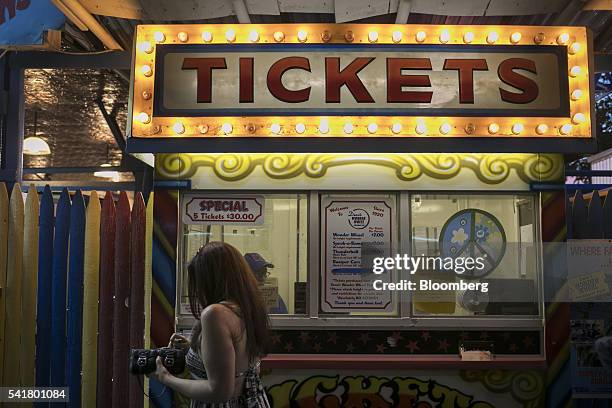 Visitors buy tickets for rides at Coney Island in the Brooklyn borough of New York, U.S., on Saturday, June 18, 2016. The summer solstice arrives on...