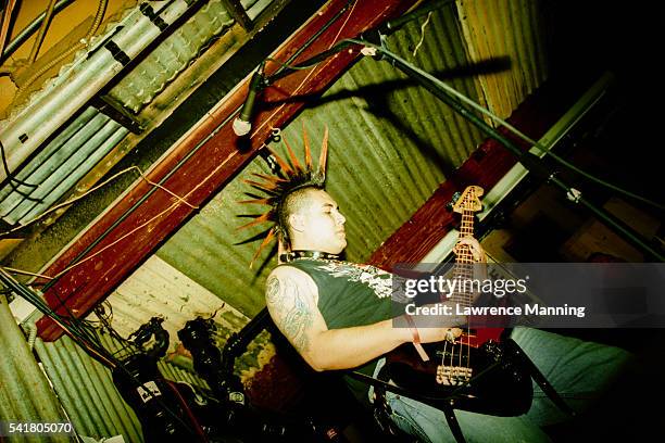 man with mohawk playing bass guitar - coiffure punk photos et images de collection