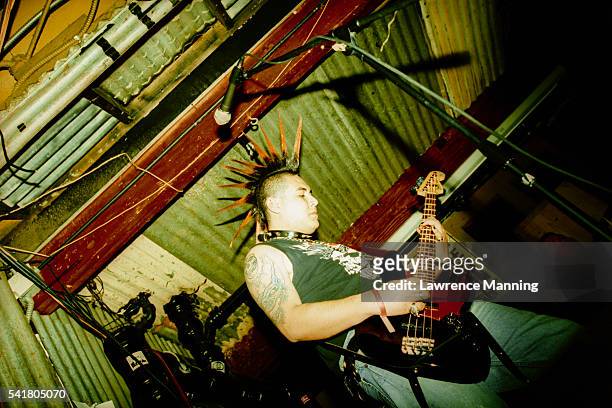 man with mohawk playing bass guitar - punkt stock pictures, royalty-free photos & images