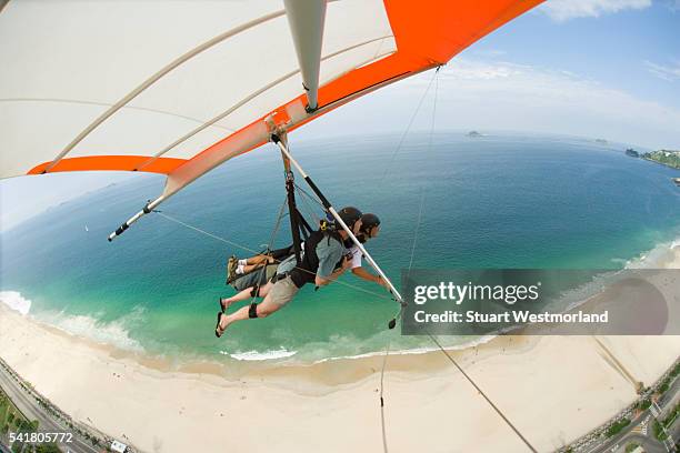 hang gliding over pepino beach - hang glider stock pictures, royalty-free photos & images