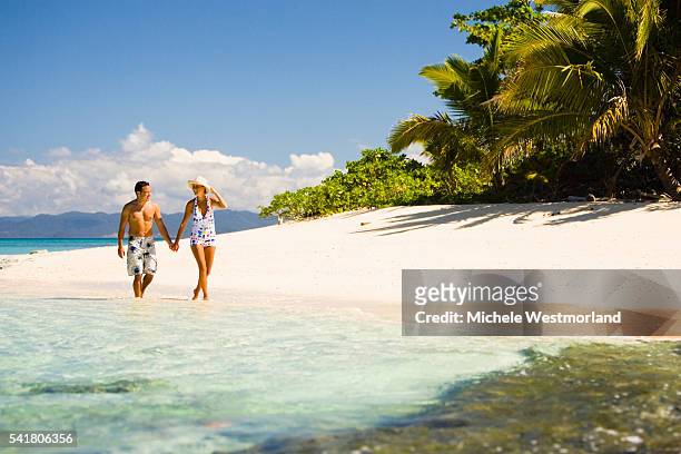 couple walking on beach - fiji stockfoto's en -beelden