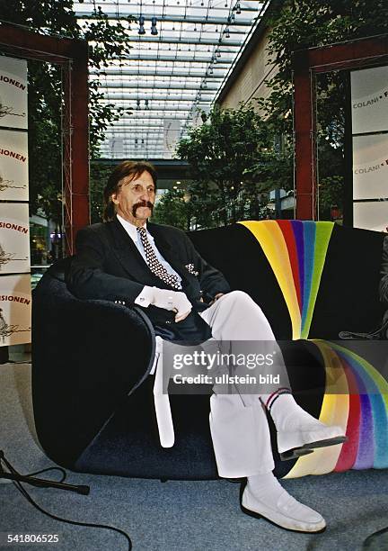 Luigi Colani*-Konstrukteur, Designer, Schweizsitzt auf einem Sofa in den PotsdamerPlatz Arkaden, Berlin