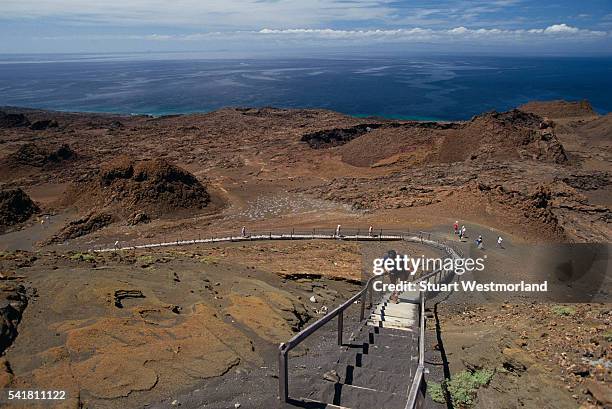 hikers climbing to summit of bartolome island - cinder cone volcano stock pictures, royalty-free photos & images