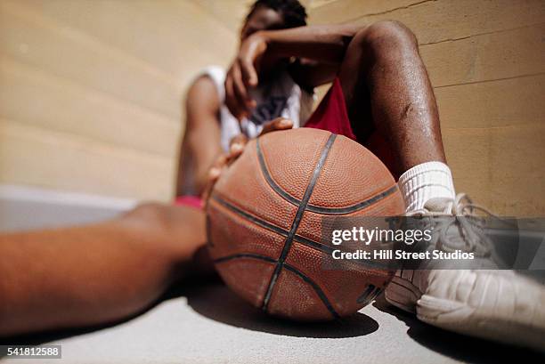 basketball player relaxing on floor - basketball defeat stock pictures, royalty-free photos & images