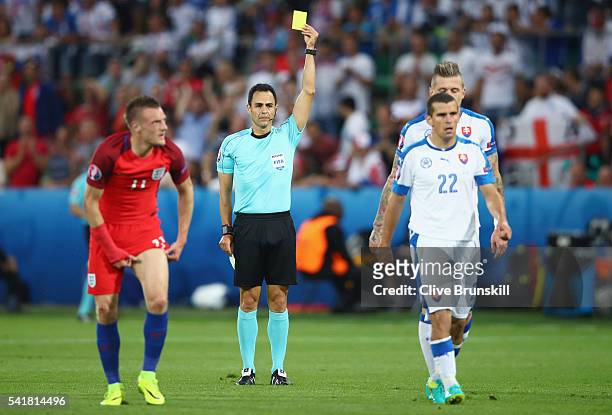 Viktor Pecovsky of Slovakia is shown a yellow card by Referee Carlos Velasco Carballo during the UEFA EURO 2016 Group B match between Slovakia and...
