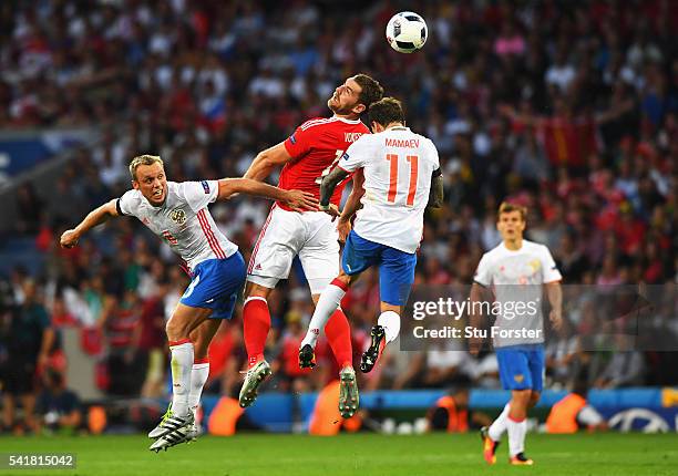 Sam Vokes of Wales competes for the ball against Denis Glushakov and Pavel Mamaev of Russia during the UEFA EURO 2016 Group B match between Russia...