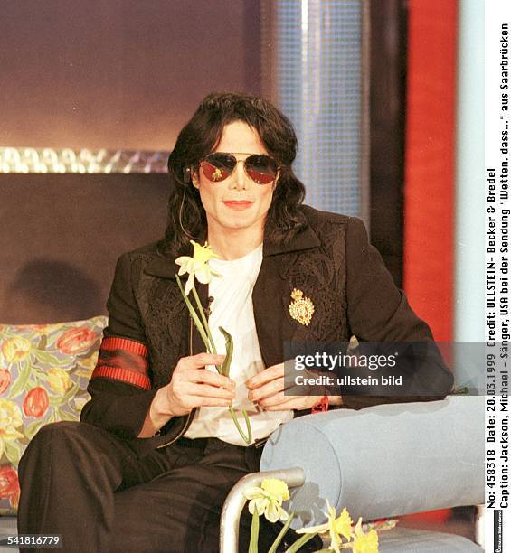 Michael Jackson *Musiker, Saenger, Komponist, USAmit einer Osterglocke in der Hand bei der Sendung "Wetten. Dass..." aus Saarbrücken, sitzt auf dem...