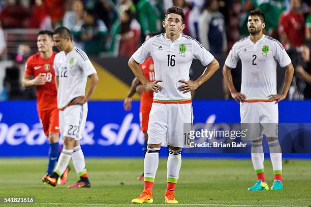 Paul Aguilar, Hector Herrera, and Nestor Araujo of Mexico react after the seventh of Chile during a Quarterfinal match between Mexico and Chile at...