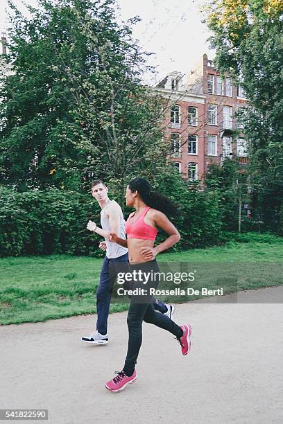 cheerful couple running outdoors in the early morning - vondelpark stockfoto's en -beelden