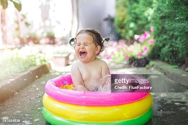 einjähriges baby spielt im babybecken - babyschwimmen stock-fotos und bilder