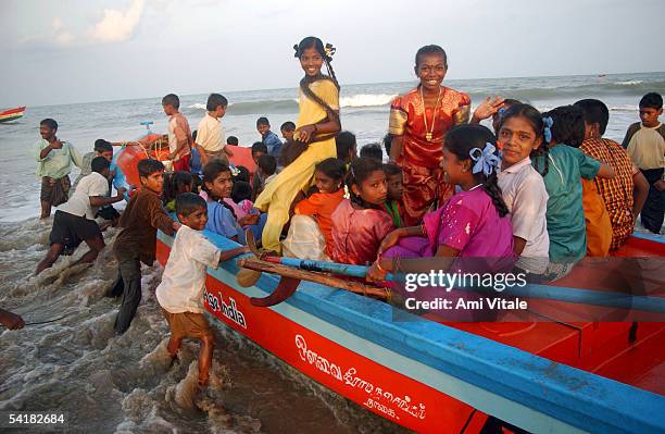 Fishing families from New Beach in Nagapattinum district in Tamil Nadu, India get into a boat as they take part in the unique ritual of reliving the...