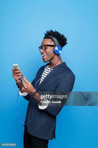 afro american guy wearing headphone using smart phone - how we listen to music stock pictures, royalty-free photos & images