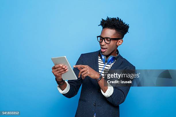heureux jeune afro-américaine en tenue à la mode, tenant la tablette numérique - homme mode studio photos et images de collection