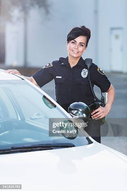 female police officer standing next to patrol car - female police officer stock pictures, royalty-free photos & images