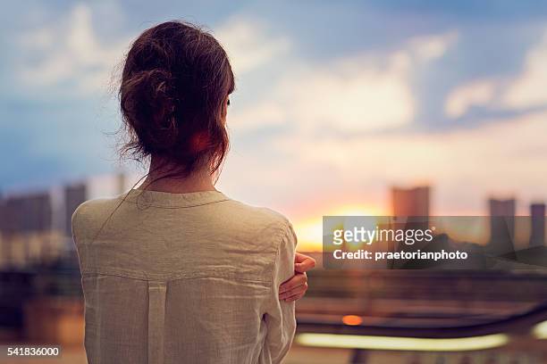 giovane ragazza guarda tramonto sopra tokyo - see foto e immagini stock
