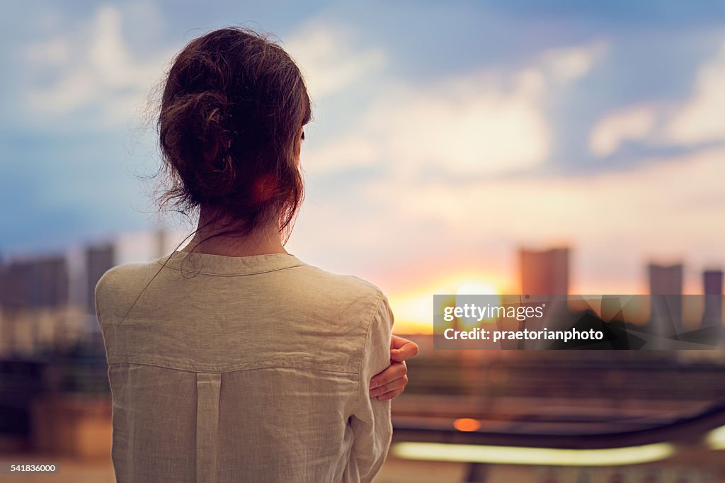 Young girl is watching sunset over Tokyo