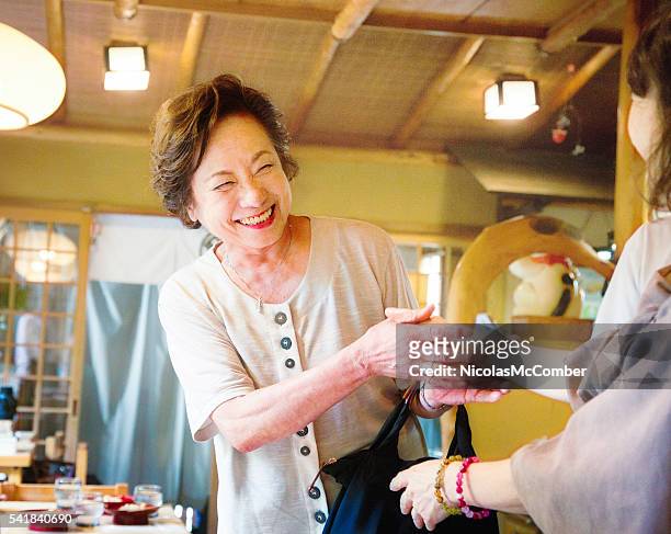 senior mulher japonesa sorrisos como ela é recebida por amigo - tia imagens e fotografias de stock