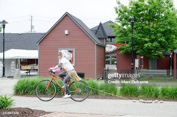 woman having her bachelorette party costumed on a bicycle - eastern townships stockfoto's en -beelden