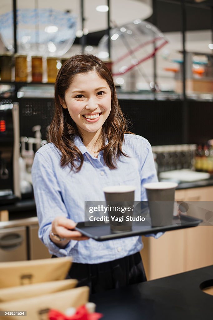 カフェに立つ女性店員のカウンター