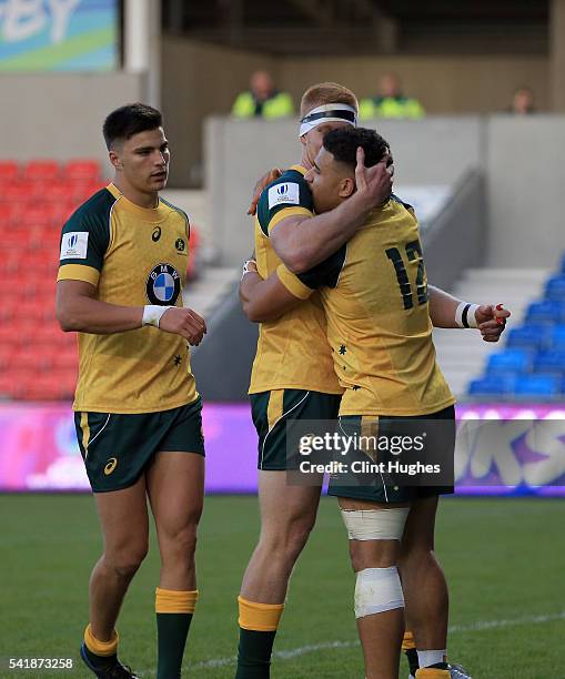 Sione Tuipolotu of Australia celebrates with team-mates Campbell Magnay and Jack Maddocks after he scores a try for his side during the World Rugby...