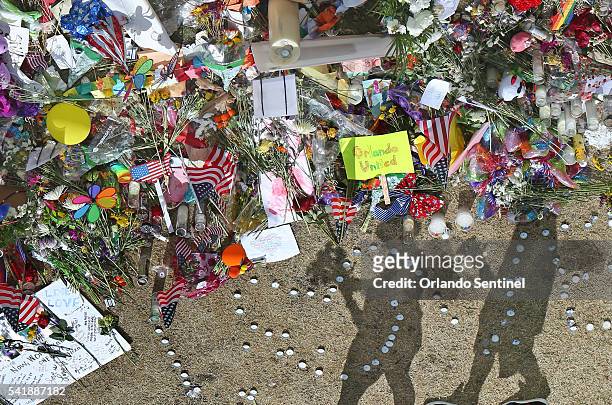 People pay their respects to an ever growing makeshift memorial at the Dr. Phillips Center for the Performing Arts in Orlando, Fla., on Monday, June...