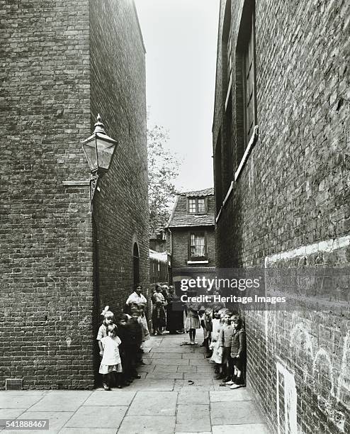 Children in an alleyway, Upper Ground Place, Southwark, London, 1923. Seen prior to slum clearance of the area, these children stand against an...