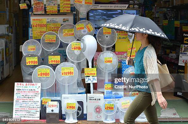 Woman walks past an electric fan store in Tokyo, Japan, June 20, 2016.