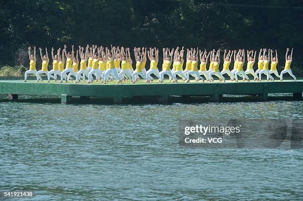 Yoga enthusiasts practice yoga on the water of Shiyan Lake on June 21, 2016 in Changsha, Hunan Province of China. About 100 yoga enthusiasts perform...