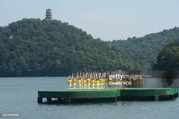 Yoga enthusiasts practice yoga on the water of Shiyan Lake on June 21, 2016 in Changsha, Hunan Province of China. About 100 yoga enthusiasts perform...