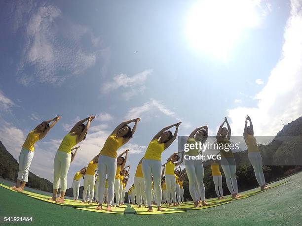 Yoga enthusiasts practice yoga on the water of Shiyan Lake on June 21, 2016 in Changsha, Hunan Province of China. About 100 yoga enthusiasts perform...