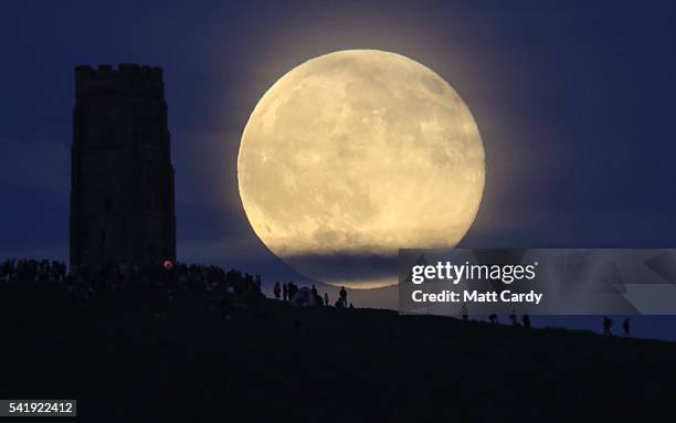 Full moon rises behind Glastonbury Tor as people gather to celebrate the summer solstice on June 20, 2016 in Somerset, England. Tonight's strawberry...