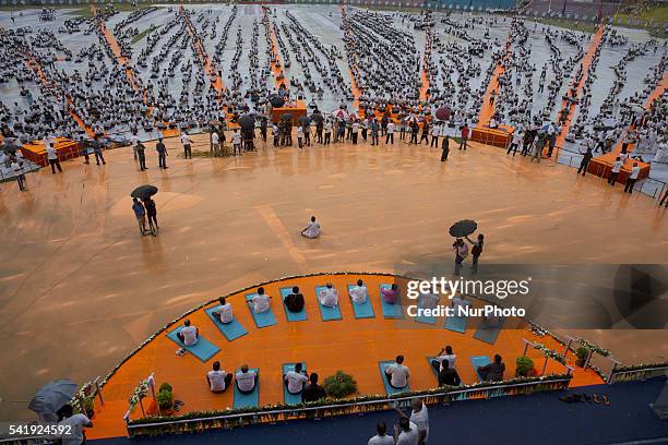 Indian people perform Yoga in a mass yoga session , to mark International Yoga Day,during heavy rains at K. D. Singh Babu stadium ,Lucknow on June...