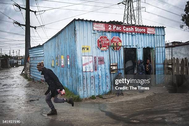 Boys stand under a shelter of a spaza shop on June 19, 2016 in Khayelitsha, South Africa. Informal settlements across the Cape Town area, many of...