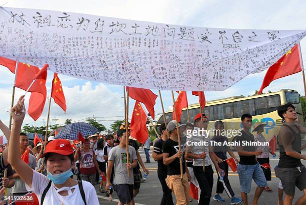 Villagers holding their signature banner march on demanding return of their leader Lin Zuluan, the Communist Party secretary of the village, as a...