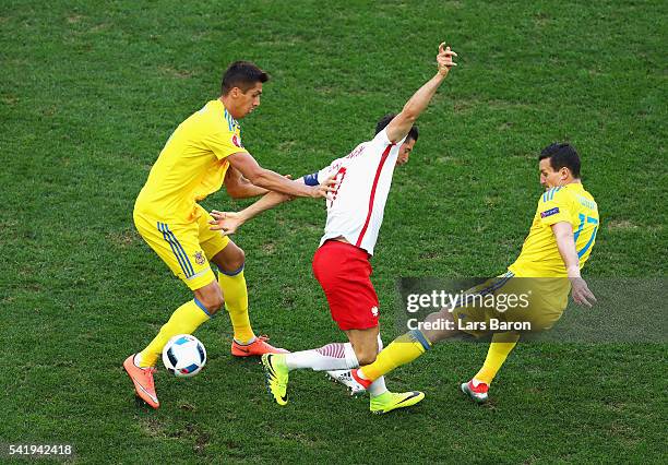 Robert Lewandowski of Poland controls the ball under pressure from Artem Fedetskiy of Ukraine during the UEFA EURO 2016 Group C match between Ukraine...