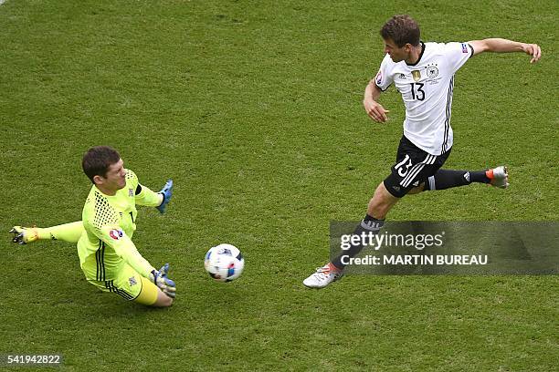 Northern Ireland's goalkeeper Michael McGovern saves a ball shot by Germany's midfielder Thomas Mueller during the Euro 2016 group C football match...