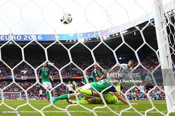 Mario Gomez of Germany scores the opening goal past Michael McGovern and Aaron Hughes of Northern Ireland during the UEFA EURO 2016 Group C match...