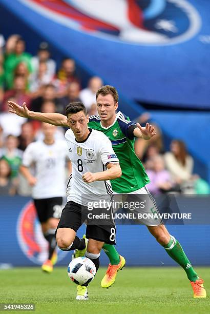 Germany's midfielder Mesut Oezil and Northern Ireland's defender Jonny Evans vie for the ball during the Euro 2016 group C football match between...