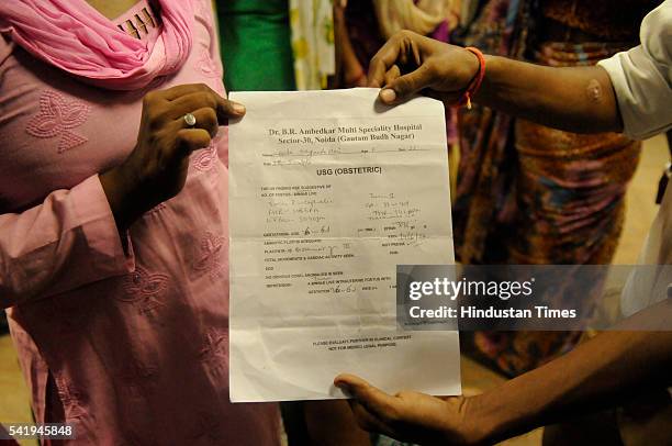 Relatives of Sangeeta Devi showing the document by Bhim Rao Ambedkar Multispeciality Hospital which mentions twins as they stage protest at...