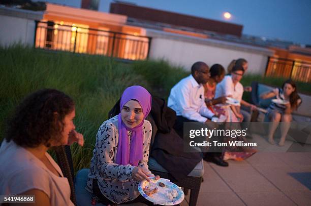 Asmaa Albaroudi, second from left, attends an iftar dinner on a roof deck in Northeast for those who participated in fasting for Ramadan, June 20,...