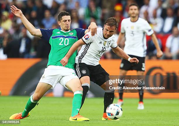 Mario Goetze of Germany and Craig Cathcart of Northern Ireland compete for the ball during the UEFA EURO 2016 Group C match between Northern Ireland...