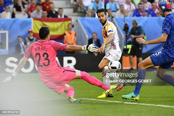 Spain's midfielder Cesc Fabregas passes the ball across Croatia's goalkeeper Danijel Subasic and Croatia's defender Vedran Corluka during the Euro...