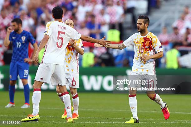 Cesc Febregas of Spain celebrates his team's first goal with his team mate Sergio Busquets during the UEFA EURO 2016 Group D match between Croatia...