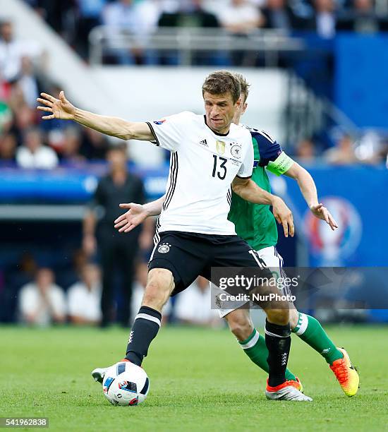 Thomas Muller is challenged by Steven Davis during the UEFA EURO 2016 Group C match between Northern Ireland and Germany at Parc des Princes on June...