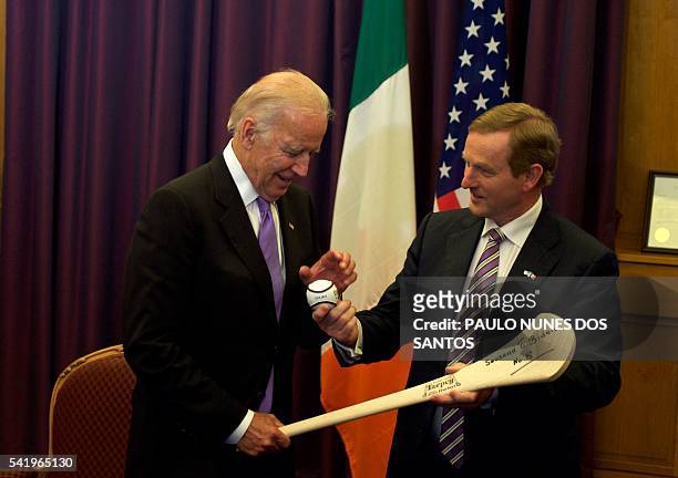 Vice President Joe Biden receives an hurl as welcome gift from Irish Prime Minister Enda Kenny during a welcome ceremony at the Government Buildings...
