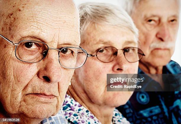 drei mürrisch senioren, zwei männer und eine frau, stirn runzeln, enttäuscht - grumpy old man stock-fotos und bilder