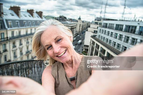 french woman take a selfie on the rooftop in paris - paris balcony stock pictures, royalty-free photos & images