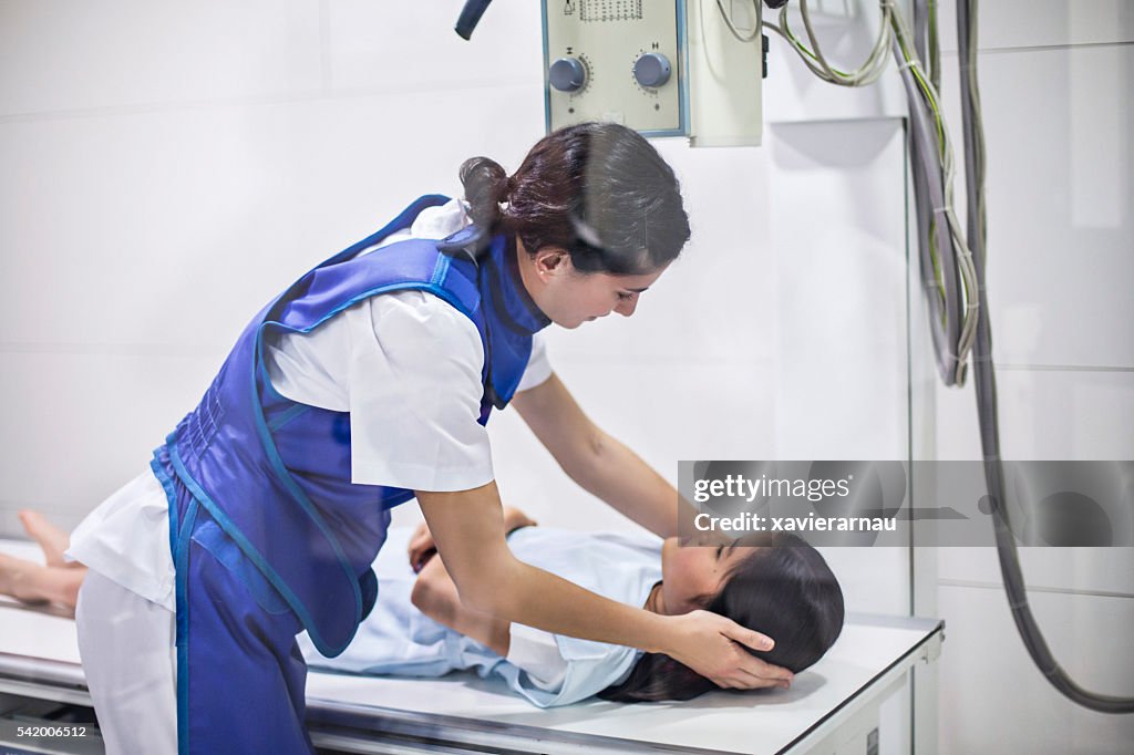 Nurse preparing child patient for an x-ray at hospital
